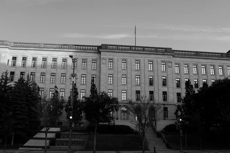 a black and white photo of a large building, a black and white photo, court session images, ((oversaturated)), late evening, high quality upload
