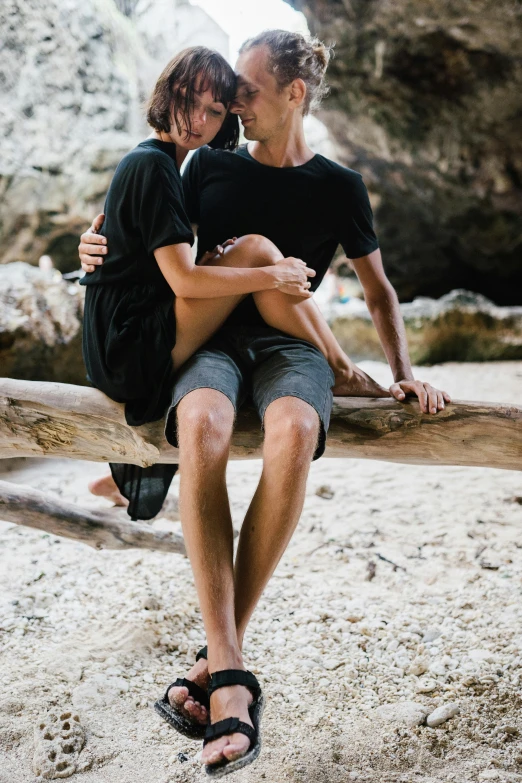 a man and a woman sitting on a log, unsplash, renaissance, wears shorts, adam ondra, embracing, black