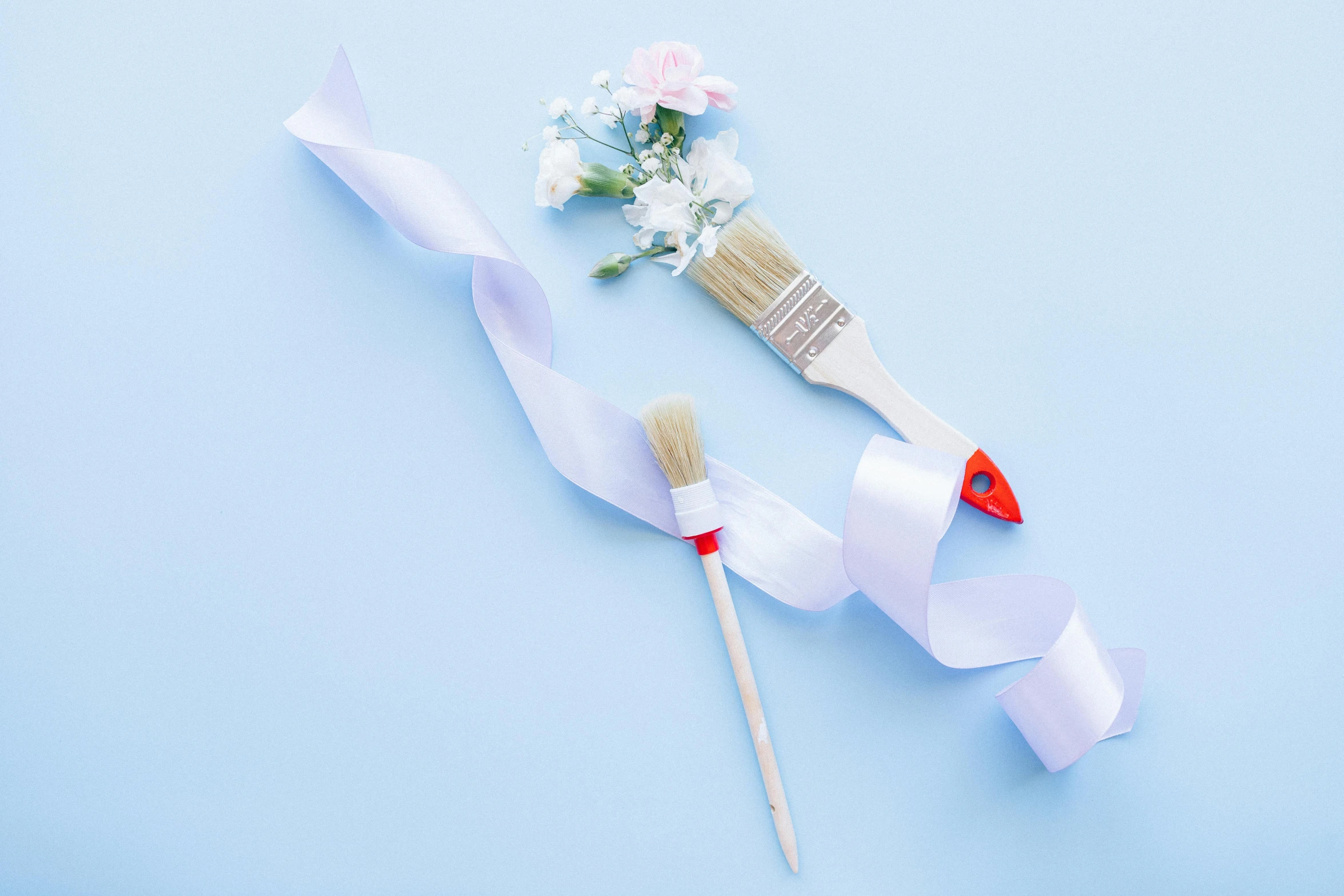 a couple of brushes sitting on top of a blue surface, inspired by artist, pexels contest winner, ribbons and flowers, white color scheme, light-blue, full product shot