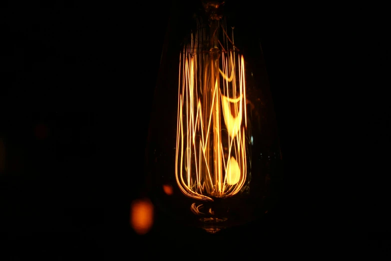 a light bulb lit up in the dark, by David Donaldson, pexels, light and space, vintage style, intricate illuminated lines, fire light, volumetric lightening