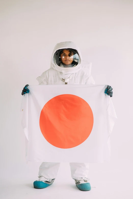 a person in a space suit holding a flag, an album cover, inspired by Koson Ohara, unsplash contest winner, ethnicity : japanese, imaan hammam, studio photo, white and orange