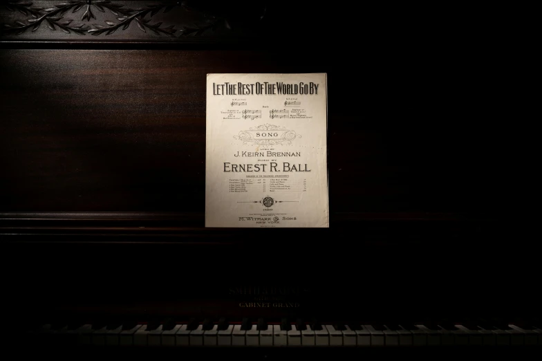 a sheet of paper sitting on top of a piano, an album cover, by Everett Warner, unsplash, art nouveau, ball, let's play, signed, end of the world