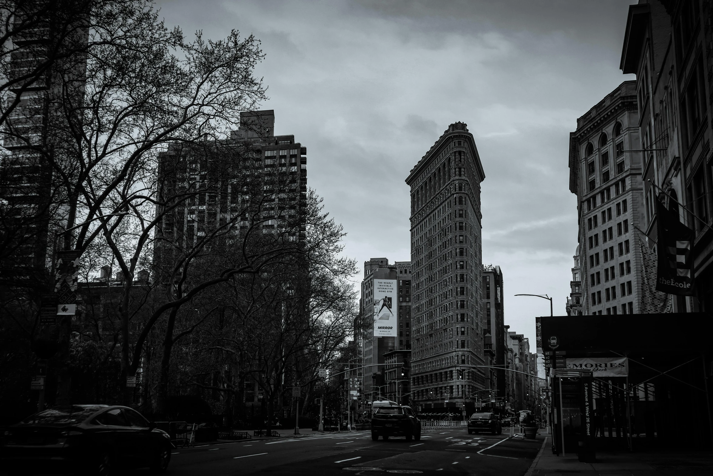 a black and white photo of a city street, inspired by Vivian Maier, unsplash contest winner, art nouveau, madison square garden, today\'s featured photograph 4k, victorian buildings, twilight in the city