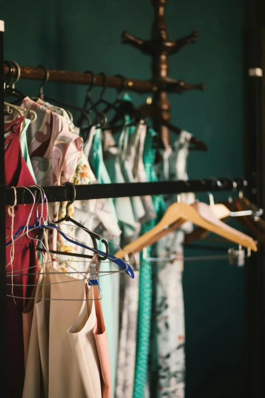 a woman standing in front of a rack of clothes, by Lee Loughridge, unsplash, renaissance, pink and teal, 1 9 2 0 s clothes, sleepwear, medium close-up shot