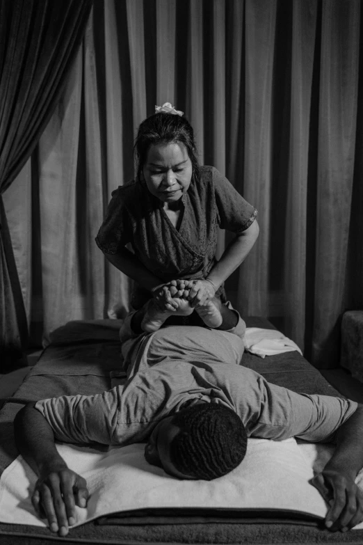 a black and white photo of a man getting a massage, by Matthias Stom, patiphan sottiwilaiphong, lady kima, ebony, uploaded