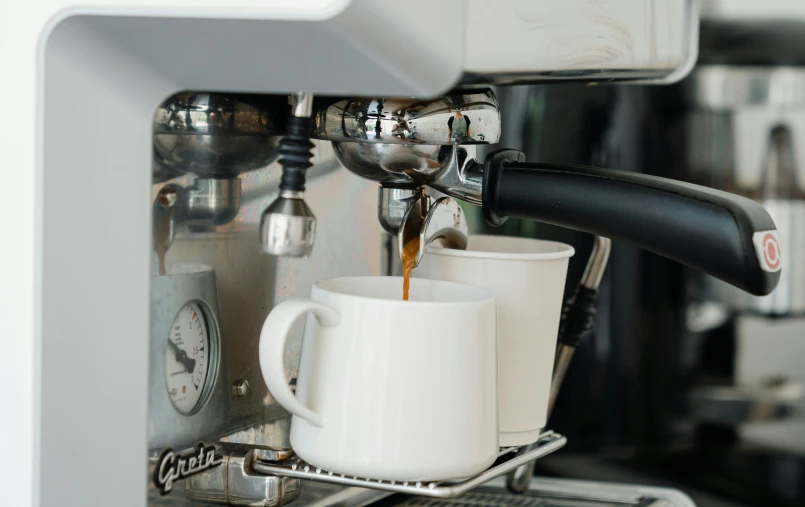 a cup of coffee being poured into a coffee machine, inspired by Richmond Barthé, glossy white metal, two cups of coffee, thumbnail, zoomed in