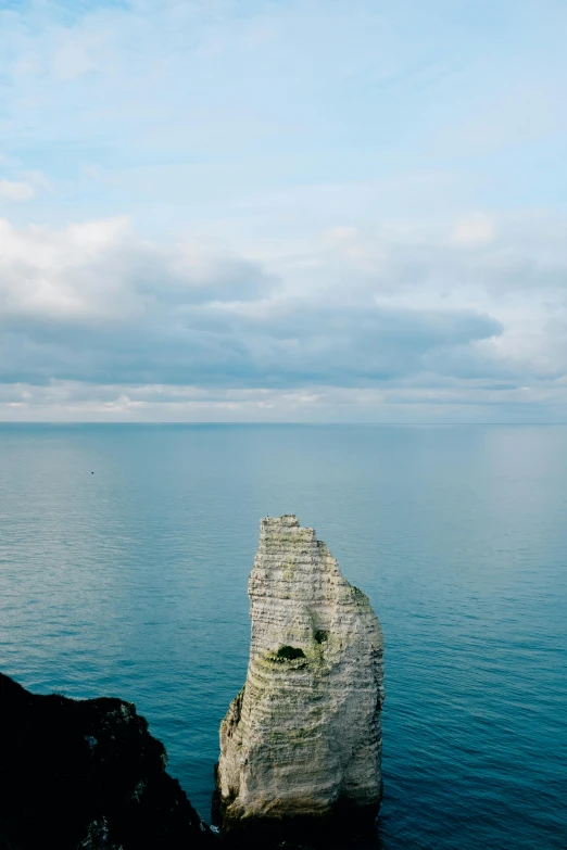 a large rock in the middle of a body of water, by Daniel Seghers, unsplash, normandy, towering high up over your view, panorama, slide show