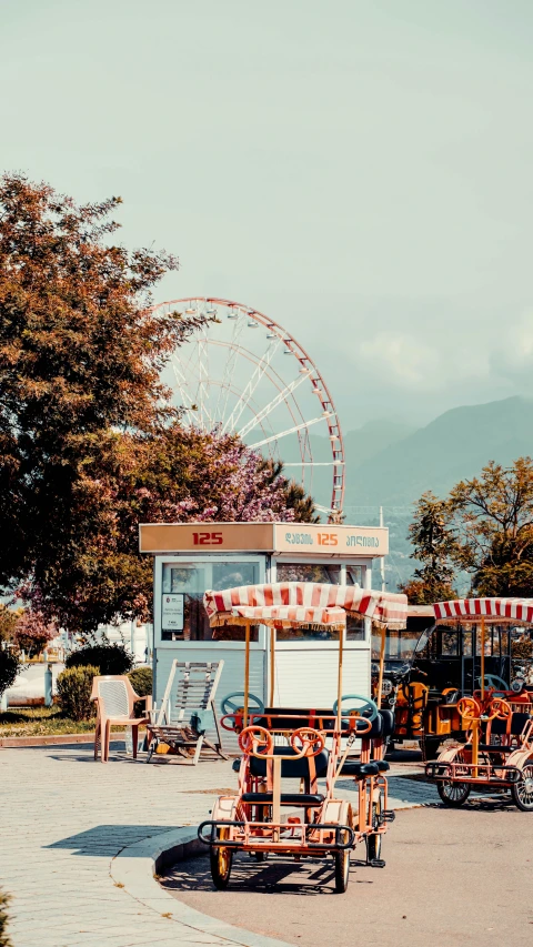 a group of vehicles parked in a parking lot next to a ferris wheel, by Niko Henrichon, pexels contest winner, lake view, food stall, profile image, the alps are in the background