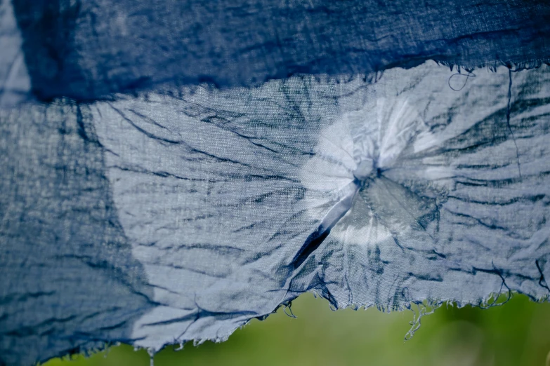 a close up of a piece of blue fabric, inspired by Jan Rustem, unsplash, process art, parasol, soft grey and blue natural light, ripped clothing, in the sun