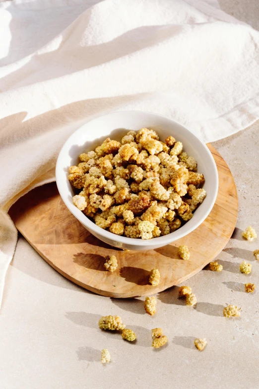 a bowl of food sitting on top of a wooden cutting board, renaissance, dried flower, bumps, thumbnail, crispy