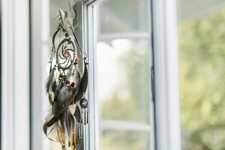 a close up of a window with a dream catcher hanging from it, hair jewellery, windowsill, stunning quality, norse inspired