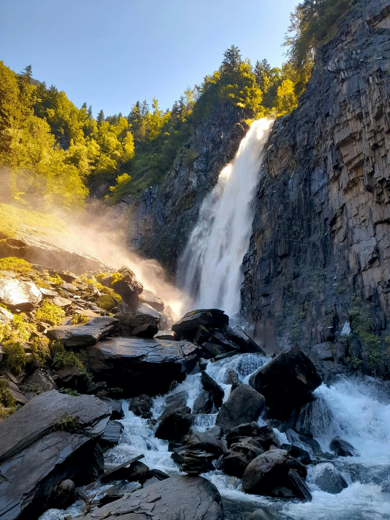 a large waterfall in the middle of a forest, full morning sun, norway mountains, 2022 photograph, guide