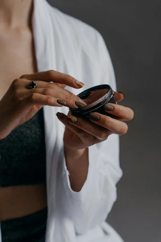 a close up of a person holding a cell phone, tiny black bra, doctors mirror, photoshoot for skincare brand, simple magic ring of poison