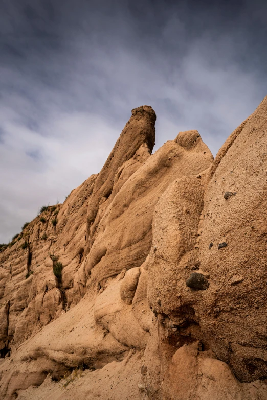 a rock formation in the desert under a cloudy sky, by Doug Ohlson, les nabis, malibu canyon, up-close, red ocher, portrait of tall