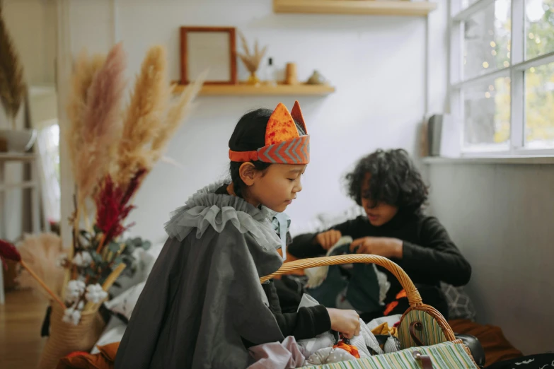 a couple of women sitting next to each other in a room, a child's drawing, pexels contest winner, wearing a crown and cape, middle eastern style vendors, dark grey and orange colours, weaving