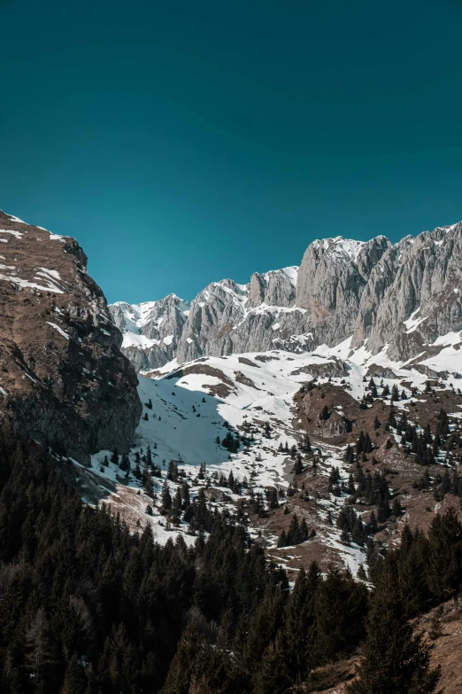 a group of people riding skis on top of a snow covered mountain, trees and cliffs, zenithal view, epic land formations, today\'s featured photograph 4k