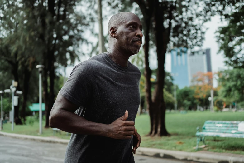 a man running in a park with trees in the background, pexels contest winner, happening, man is with black skin, older male, sweating intensely, profile image