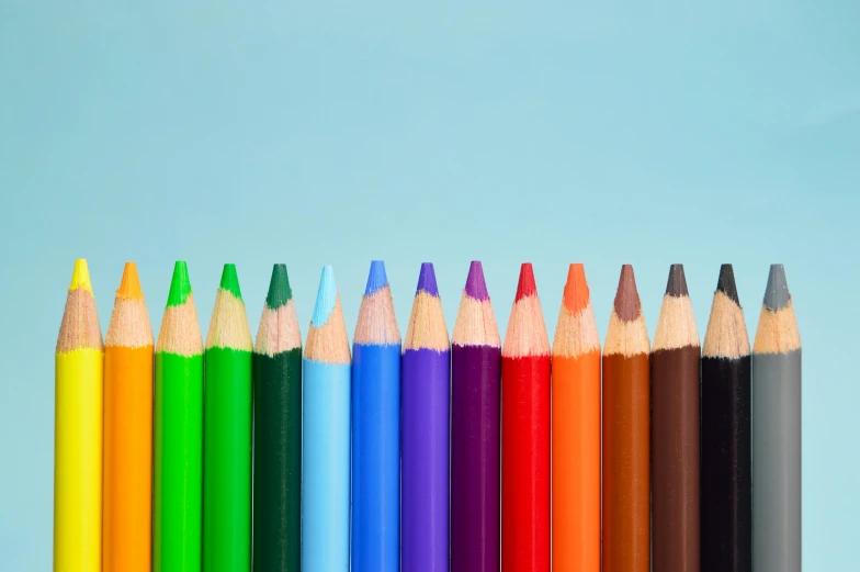 a row of colored pencils sitting next to each other, trending on pexels, crayon art, blue background colour, dezeen, diverse ages, coloured in teal and orange