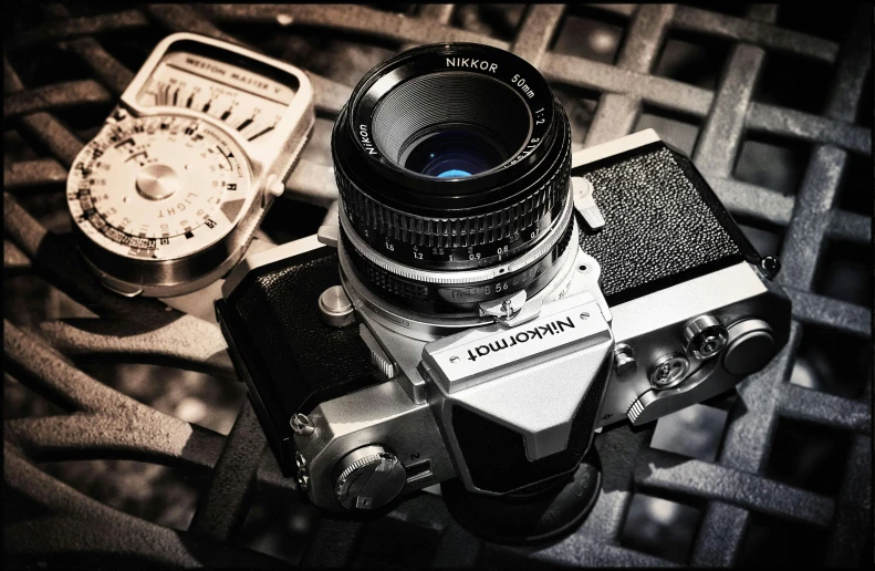 a camera sitting on top of a table next to a pocket watch, a black and white photo, by Niko Henrichon, unsplash, photorealism, 1970s cinema camera, with nikon cameras, anime style mixed with fujifilm, hasselblad film bokeh
