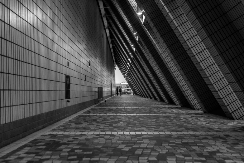 a black and white photo of a walkway, by Erik Pevernagie, pexels contest winner, sydney opera house, f / 1. 9 6. 8 1 mm iso 4 0, square lines, 2 people