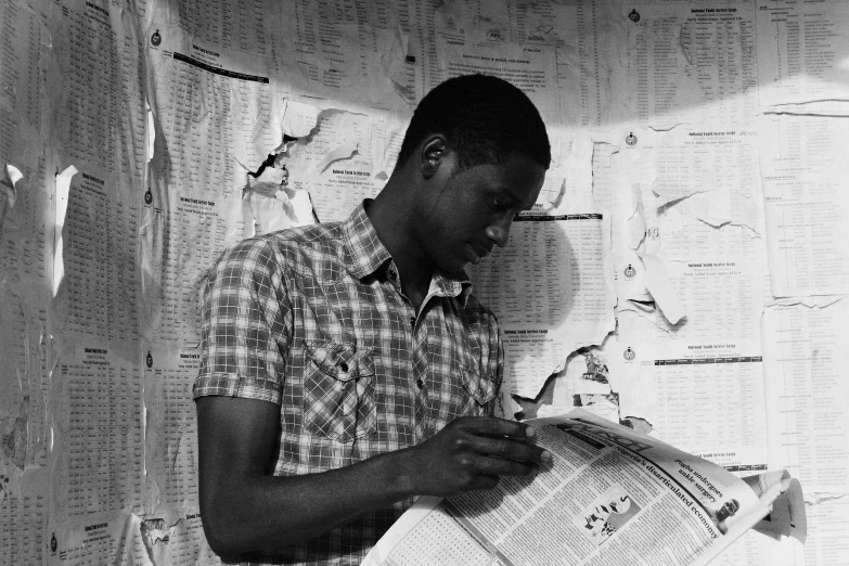 a black and white photo of a man reading a newspaper, by Robert Feke, visual art, emmanuel shiru, studious, el anatsui, trying to study