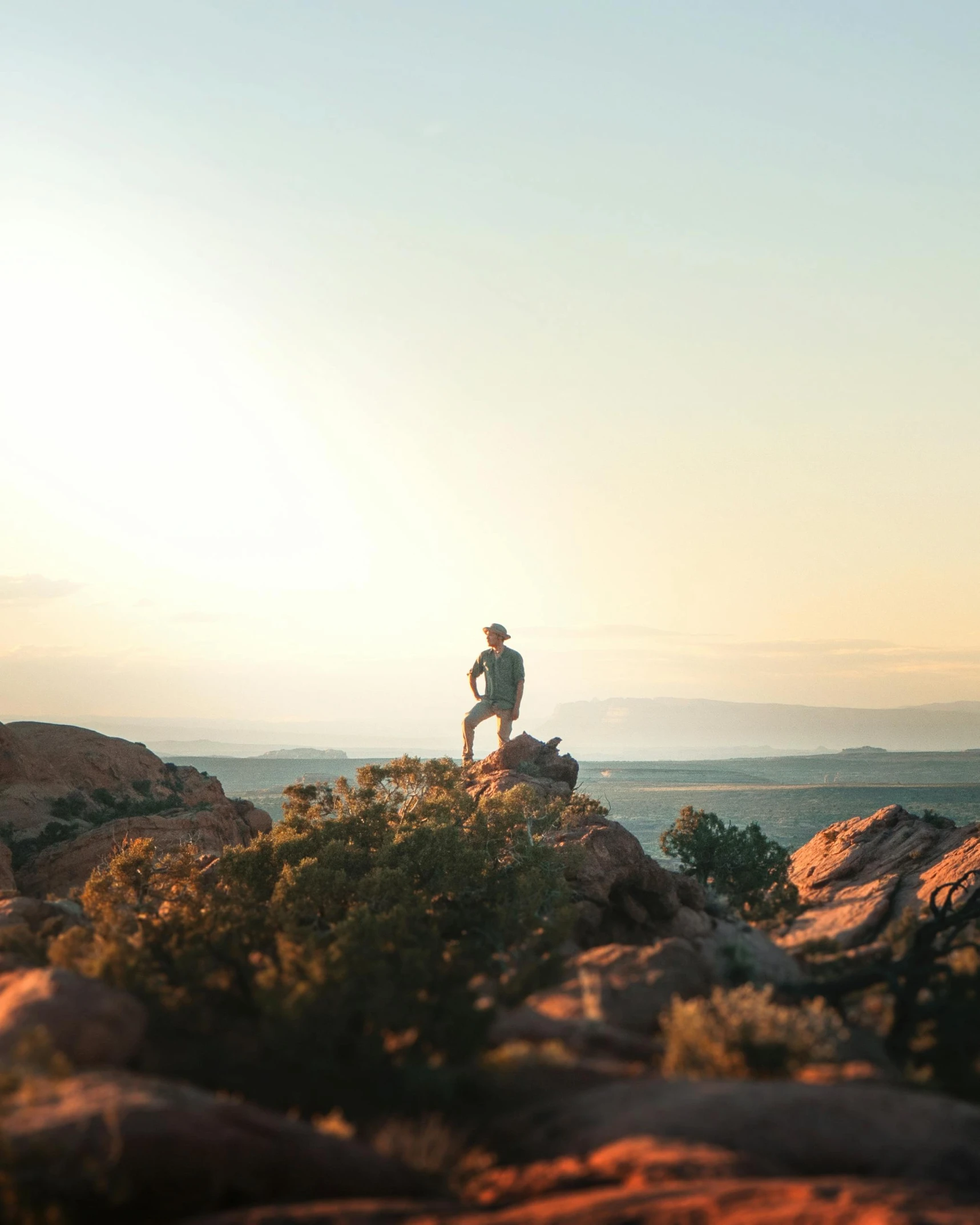 a man standing on top of a mountain next to a dog, unsplash contest winner, australian tonalism, sitting on a martian rock, golden hour 4k, moab, looking onto the horizon