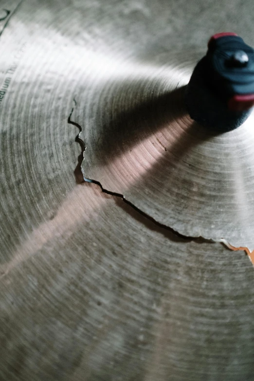 a close up of a beater on a drum, an album cover, auto-destructive art, large cracks, woodlathe, ash falling, satisfying