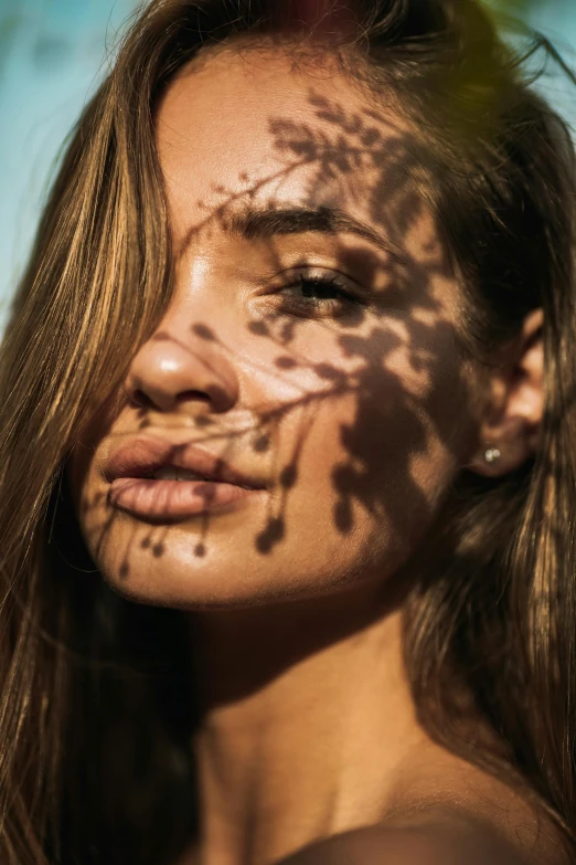 a beautiful young woman with tattoos on her face, inspired by Elsa Bleda, trending on pexels, shadows from trees, tanned, light stubble, half face