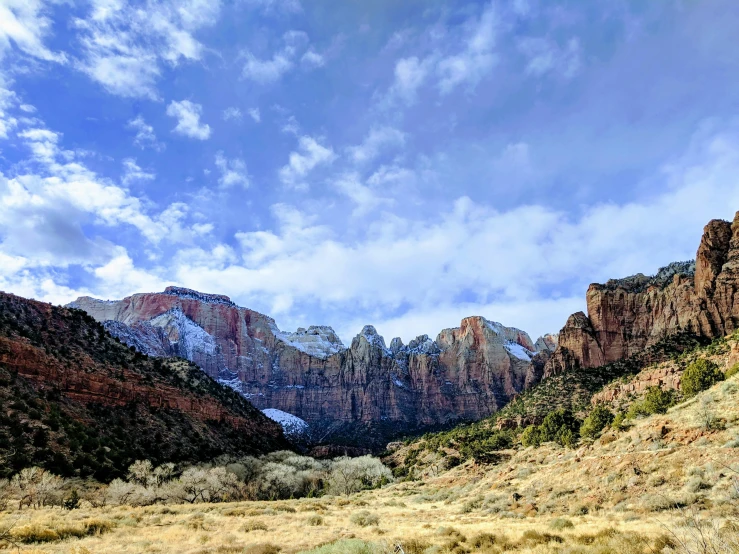 the mountains are covered in snow on a sunny day, by Doug Wildey, unsplash contest winner, sheer cliffs surround the scene, square, utah, white marble buildings