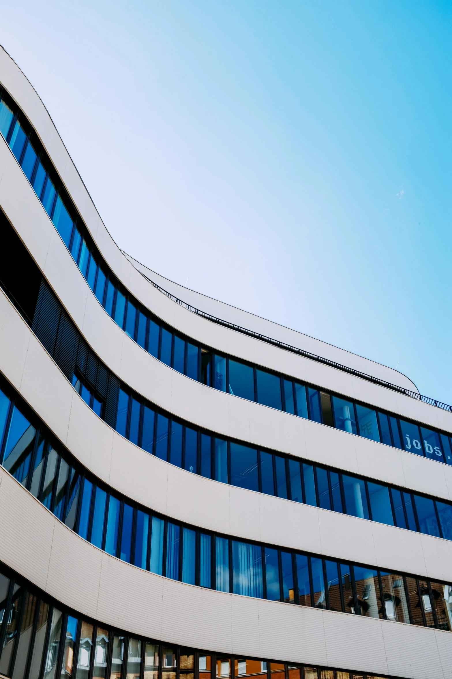 a large white building with lots of windows, unsplash, modernism, blue sky, rounded lines, close-up photograph, artsationhq