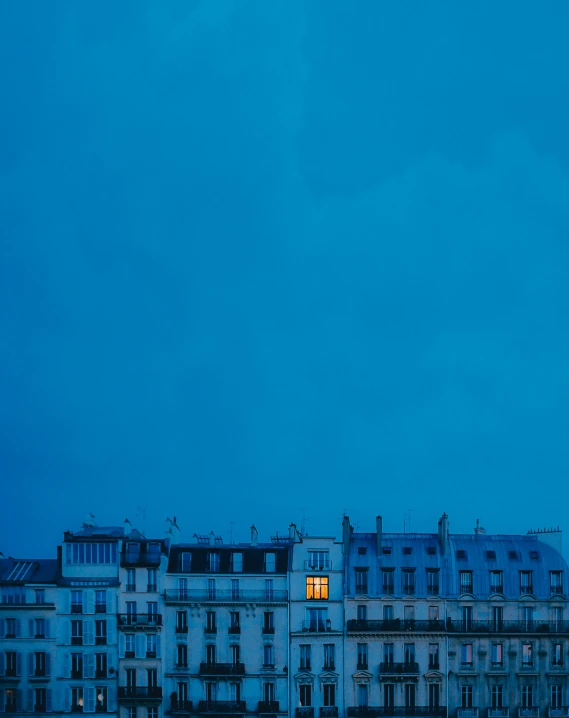 a large clock tower sitting in the middle of a city, an album cover, by Pierre Mion, unsplash contest winner, paris school, cold blue light from the window, moody : : wes anderson, minimalist photorealist, blue night
