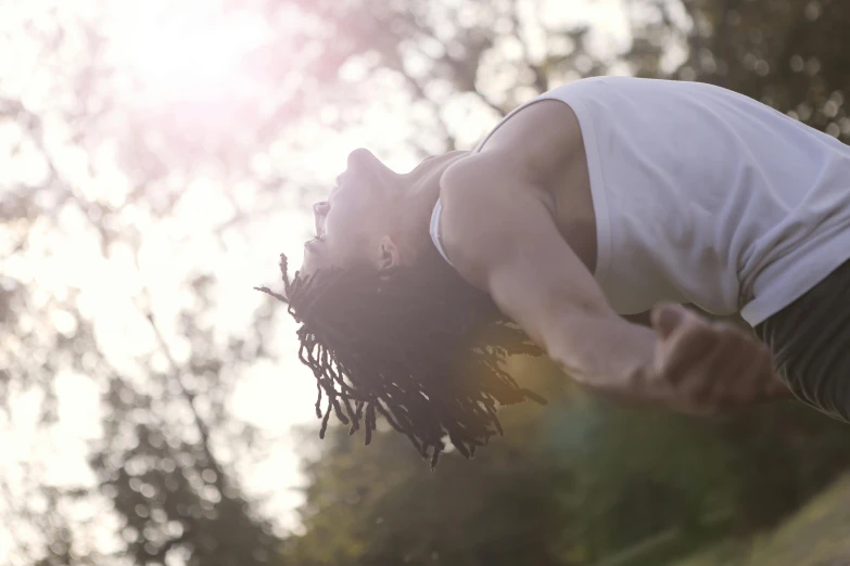 a man flying through the air while riding a skateboard, pexels contest winner, happening, chief keef in the garden of eden, summer morning light, curls on top of his head, young woman looking up