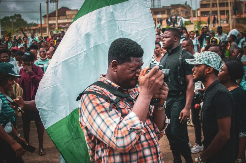 a man holding a large green and white flag, by Bernardino Mei, pexels, giga chad crying, adebanji alade, center of image, 🤬 🤮 💕 🎀