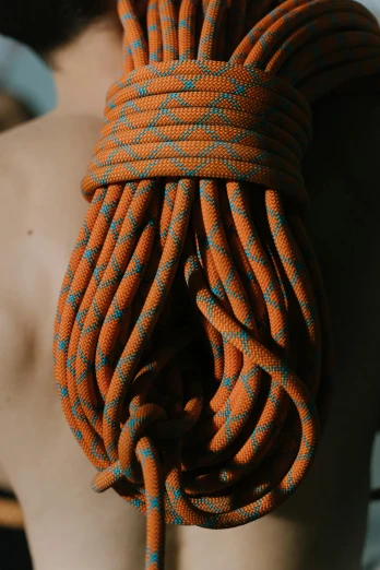 a close up of a rope on a person's back, a colorized photo, inspired by Elsa Bleda, pexels contest winner, rock climber, orange body, detailed product shot, multi-part