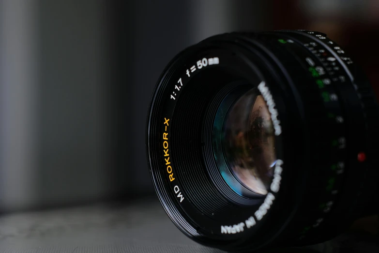 a close up of a camera lens on a table, by Adam Rex, pexels contest winner, photorealism, medium format. soft light, f1.8 bokeh, headshot, low angle photograph