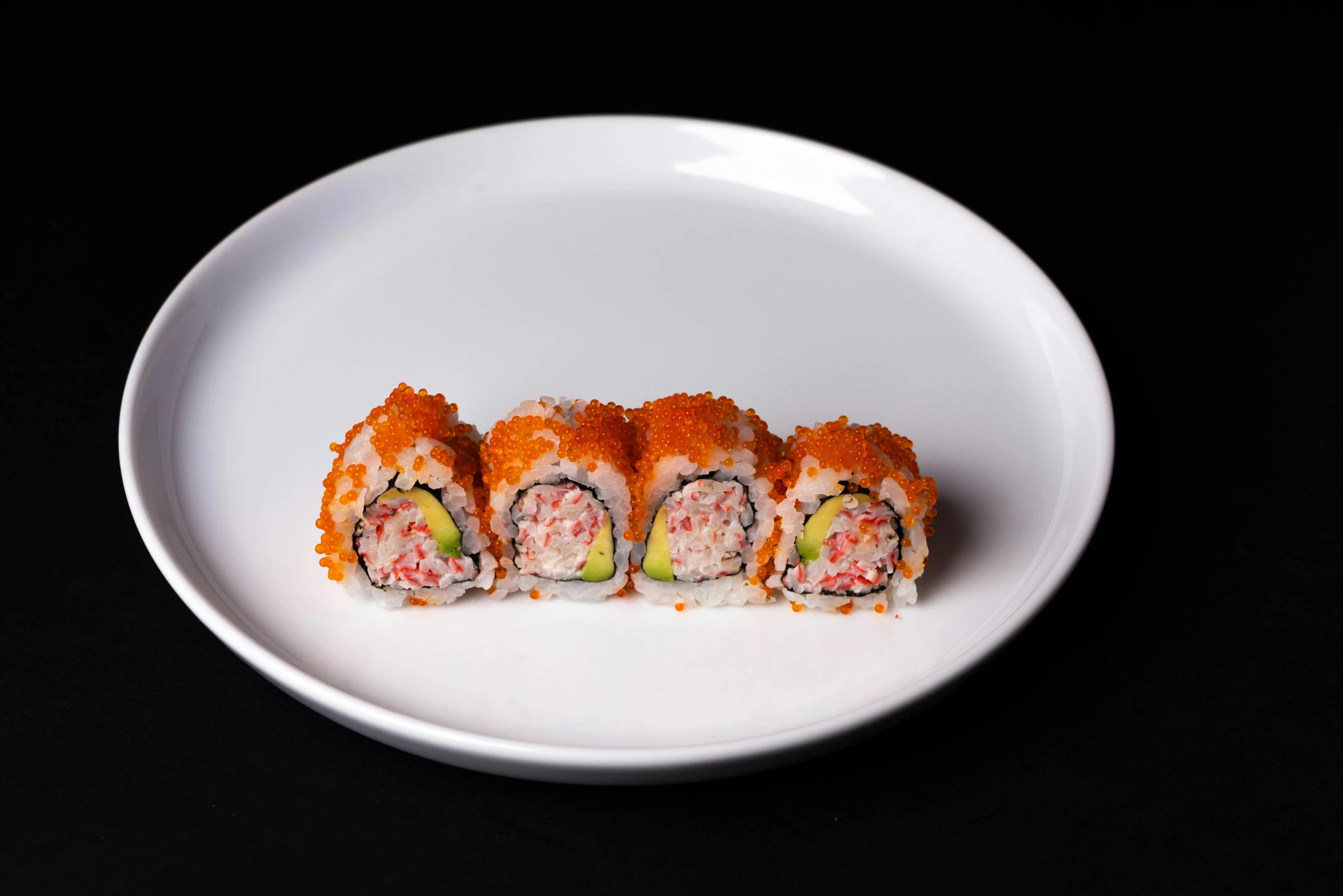 a white plate topped with sushi on top of a black table, detailed product image, 3/4 front view, fireball, neon orange