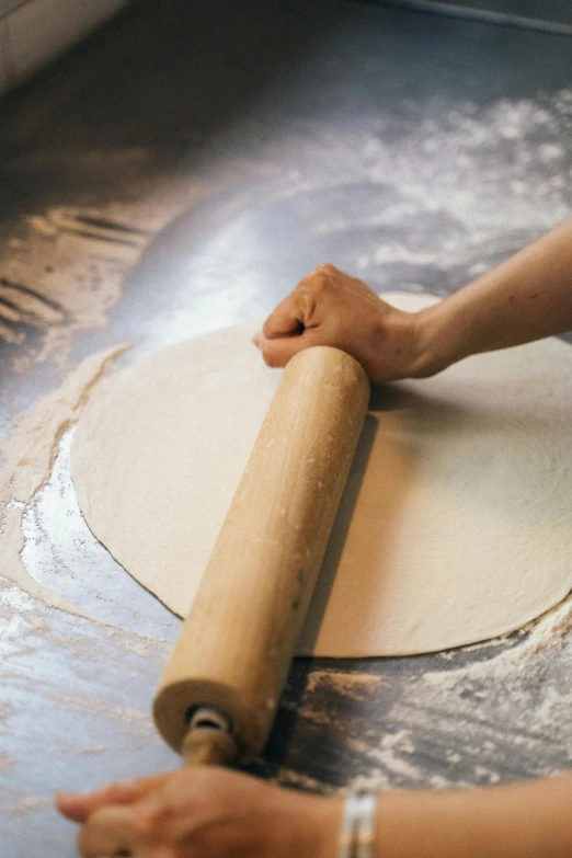 a person rolling out dough on a table, trending on pexels, process art, studio floor, circular, seasonal, tall