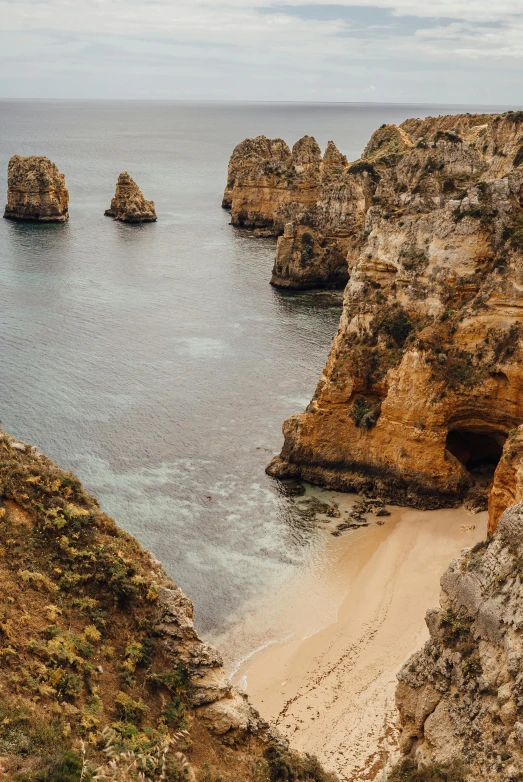 a man standing on top of a cliff next to the ocean, majestic spires, portugal, slide show, gigapixel photo