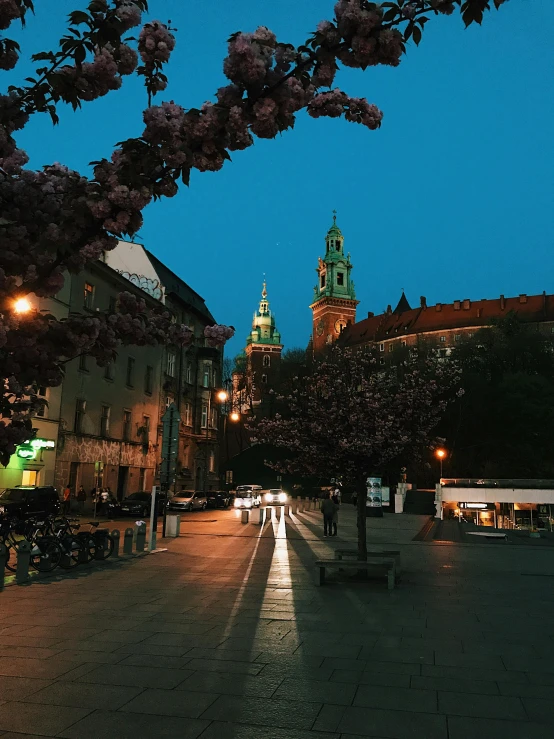 a city street at night with a clock tower in the background, a picture, by Emma Andijewska, during spring, profile image, poland, thumbnail