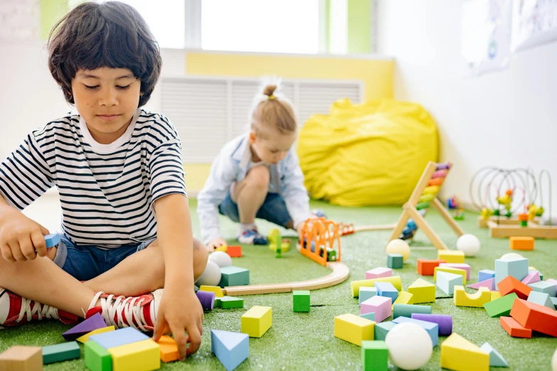 two children playing with wooden blocks on the floor, pexels contest winner, photo of a classroom, yellow carpeted, 15081959 21121991 01012000 4k, low depth field effect