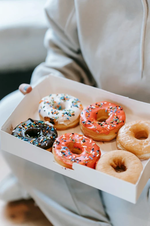 a person holding a box of assorted donuts, melbourne, sugar sprinkled, milk, thumbnail