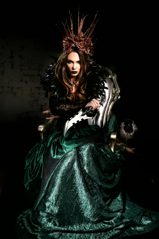 a woman in a green dress sitting in a chair, an album cover, inspired by Hans Makart, gothic art, megan fox witch queen, ornate cosplay, fierce look, /!\ the sorceress