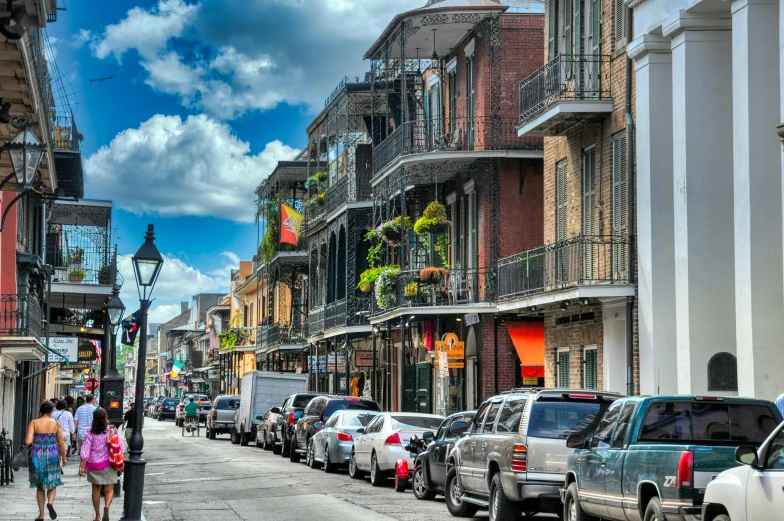 a group of people walking down a street next to tall buildings, renaissance, new orleans, cars parked underneath, a quaint, profile image
