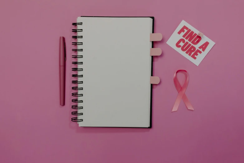 a notepad, pen, and pink ribbon on a pink background, happening, tumours, background image, multiple stories, no - text no - logo