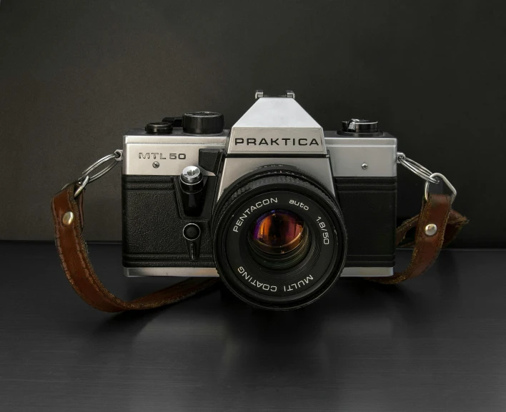 a camera sitting on top of a table, a picture, leather straps, ((photorealistic)), medium wide front shot, practice