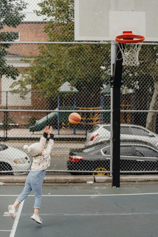 a woman standing on top of a tennis court holding a racquet, an album cover, unsplash, playing basketball, kids playing, neighborhood, humans of new york