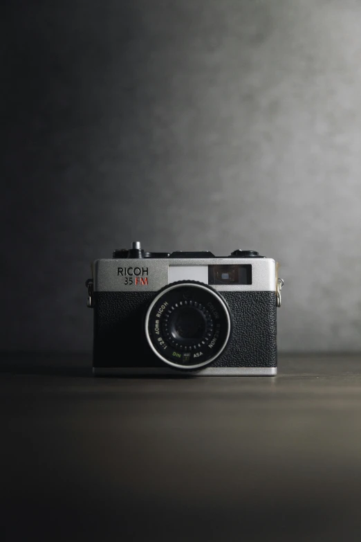 a camera sitting on top of a wooden table, by Nōami, unsplash contest winner, photorealism, dieter rams, hyper reali sm, on a gray background, 35mm of a very cute