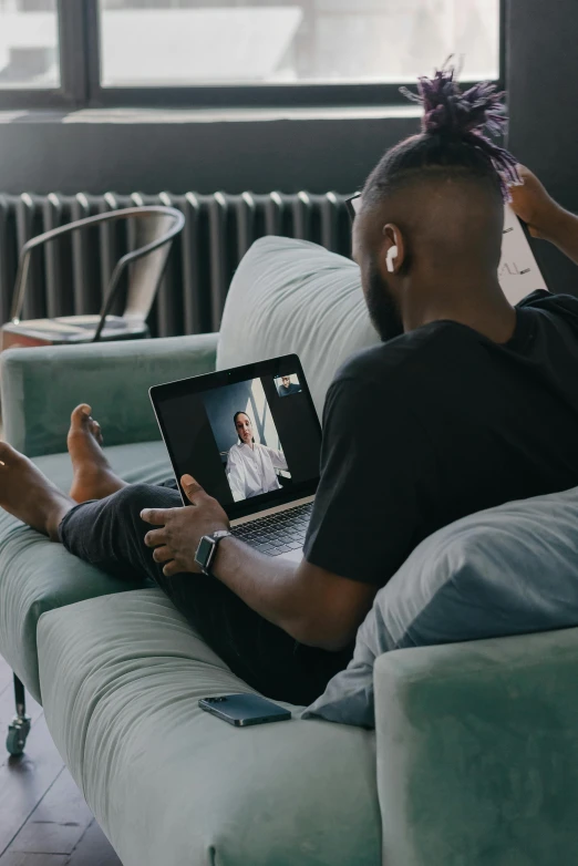 a man sitting on a couch using a laptop, pexels contest winner, video art, black man, reuniting, couple on bed, long distance photo