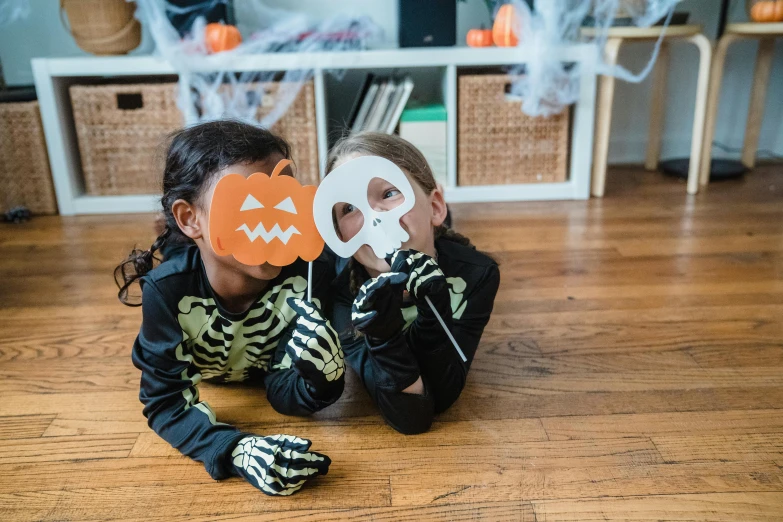 a couple of kids sitting on top of a wooden floor, pexels contest winner, vanitas, halloween decorations, mask off, ( ( ( skeleton ) ) ), kids playing