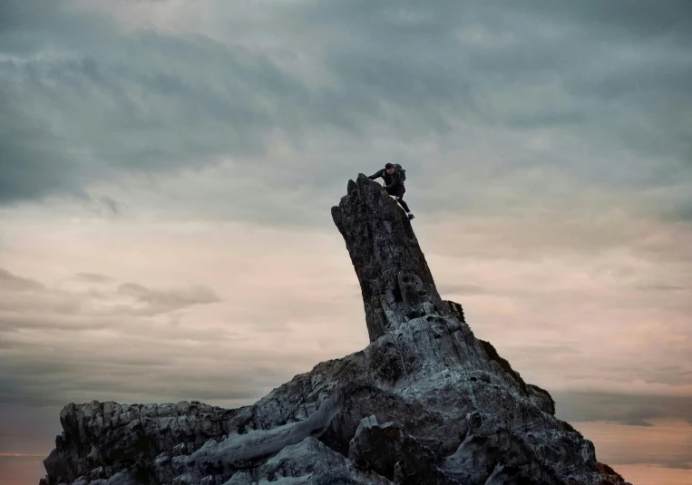 a group of people sitting on top of a rock, inspired by Michal Karcz, pexels contest winner, romanticism, man carving himself out of stone, movie still from game of thrones, sharp edge, upsetting